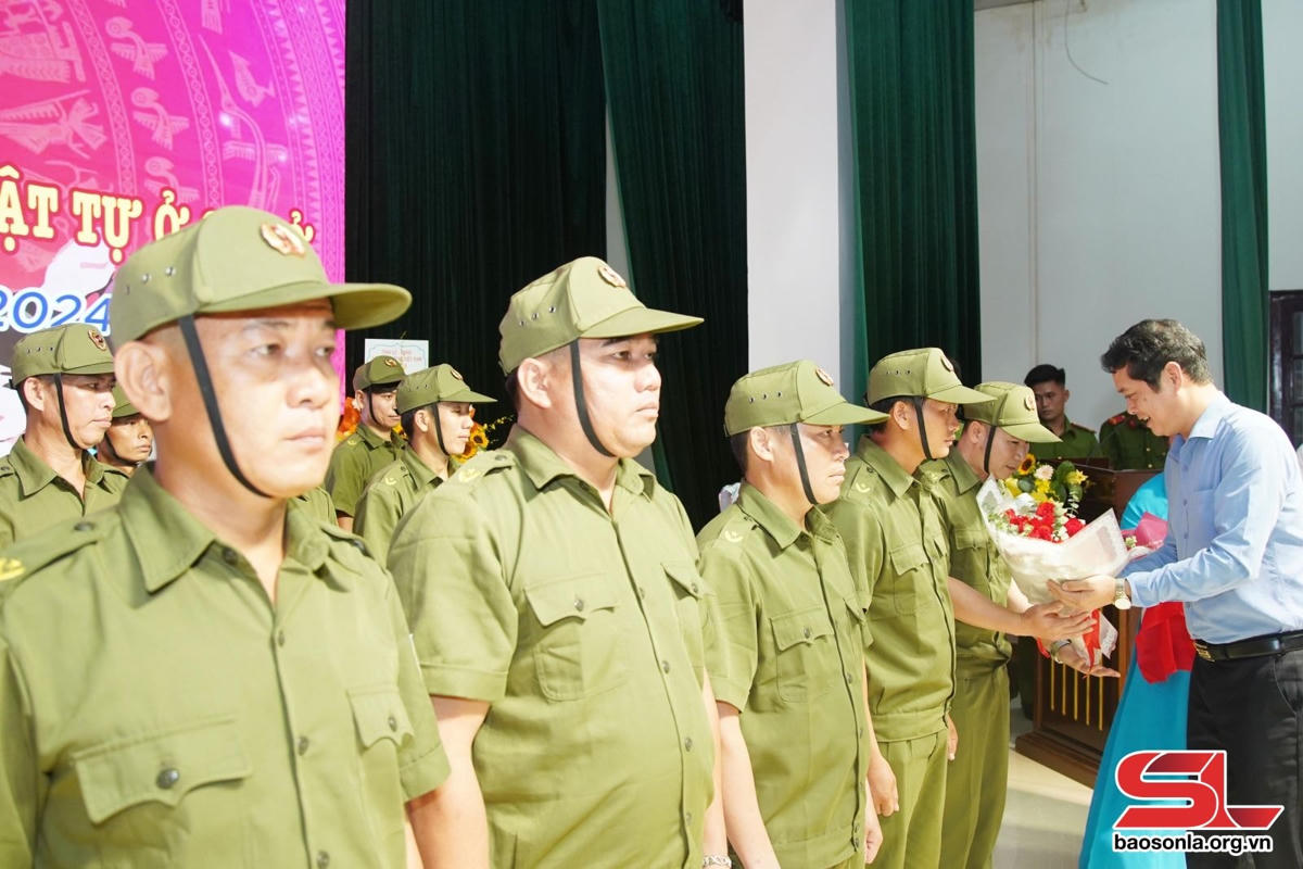 Đồng chí Vi Đức Thọ tặng hoa chúc mừng thành viên các tổ bảo vệ ANTT.