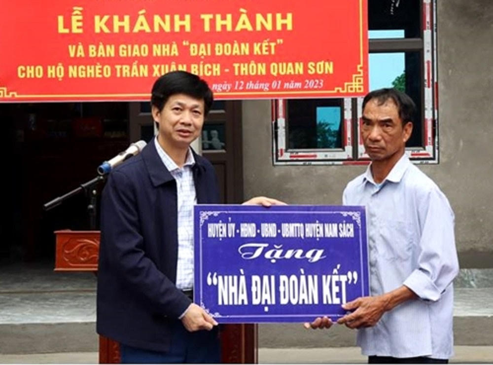 Ông Trần Xuân Bích (bên phải) - hộ nghèo ở xã An Sơn, huyện Nam Sách trong buổi lễ nhận nhà Đại đoàn kết.