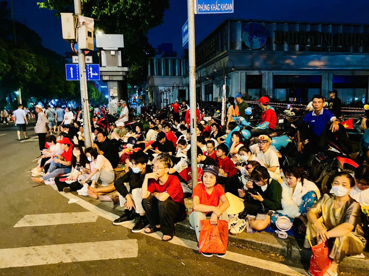 Rất đông người dân ngồi chờ trên trên vỉa hè đường Phùng Khắc Khoan để chứng kiến thời khắc trọng đại.