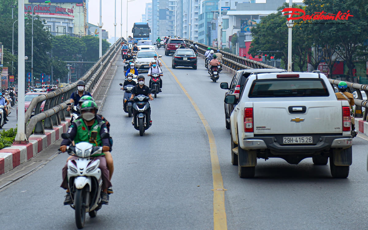 Hàng dài xe máy nối đuôi nhau đi lên cầu vượt.