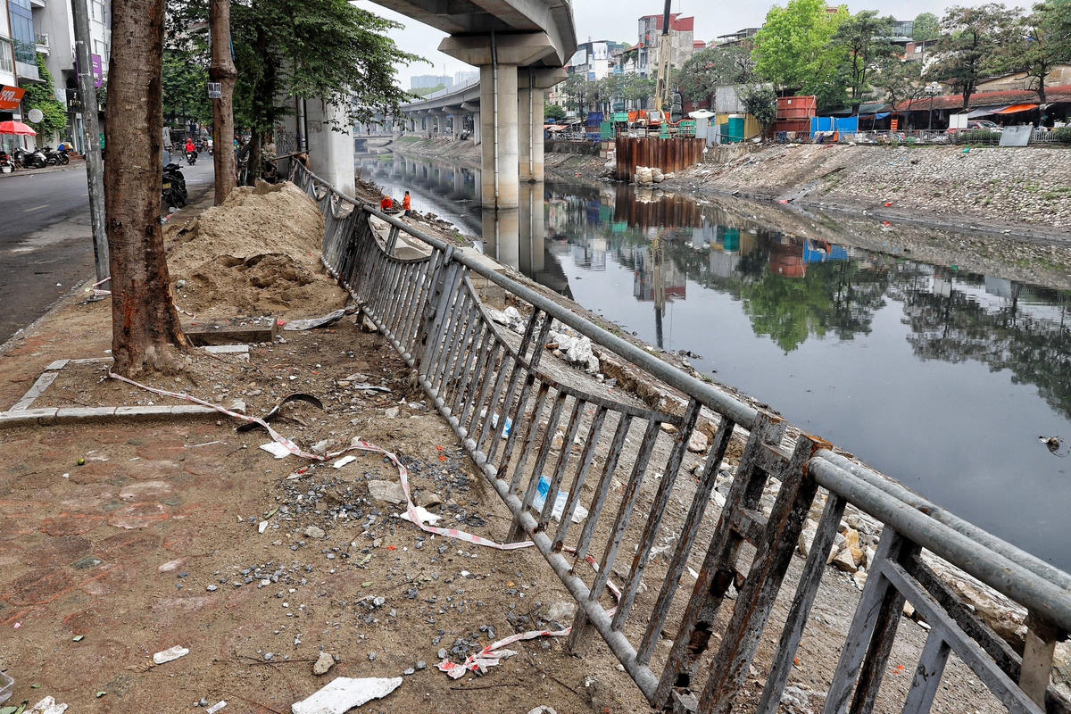 Hình ảnh vật liệu xây dựng ngang nhiên được chất đống trên vỉa hè khiến cả đoạn dài lan can bị nghiêng ngả.