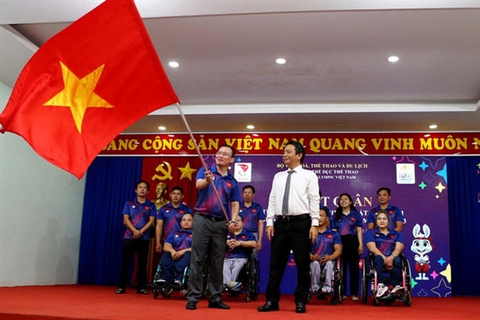 Thứ trưởng Hoàng Đạo Cương trao cờ cho Trưởng đoàn thể thao người khuyết tật Việt Nam tham dự Đại hội. Ảnh: H.Tùng/Trang điện tử TCTDTT. 