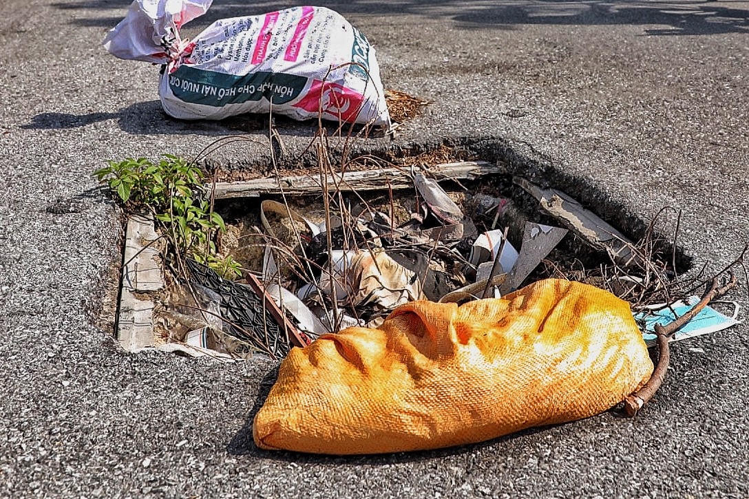 Để che vị trí không còn nắp cống, người dân sử dụng các bì tải rác để cảnh báo cho người đi tập thể dục.