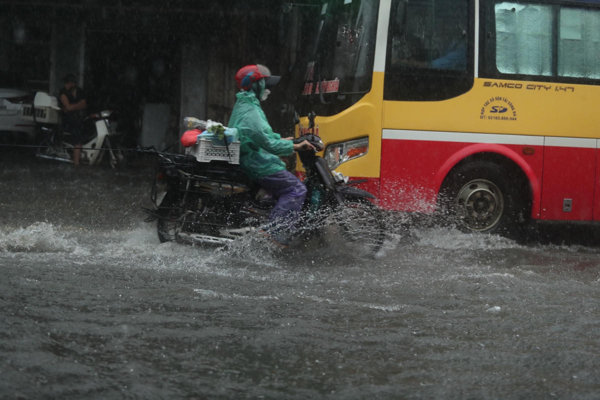 [ẢNH] Hà Nội mưa 'trắng trời', nhiều người phải dắt xe vì ngập nặng