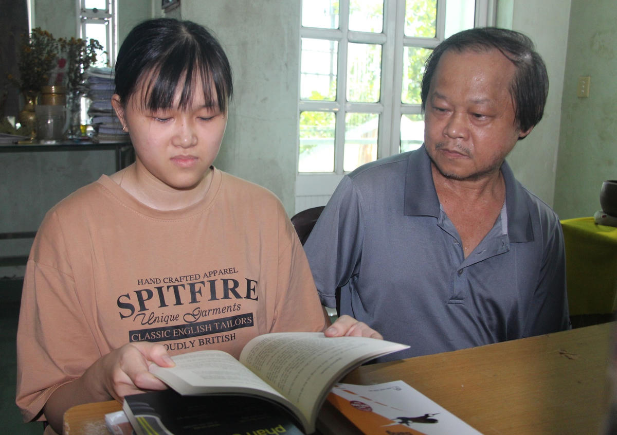 Em Nguyễn Quỳnh Giang đang ngồi học bài bên người thân gia đình.