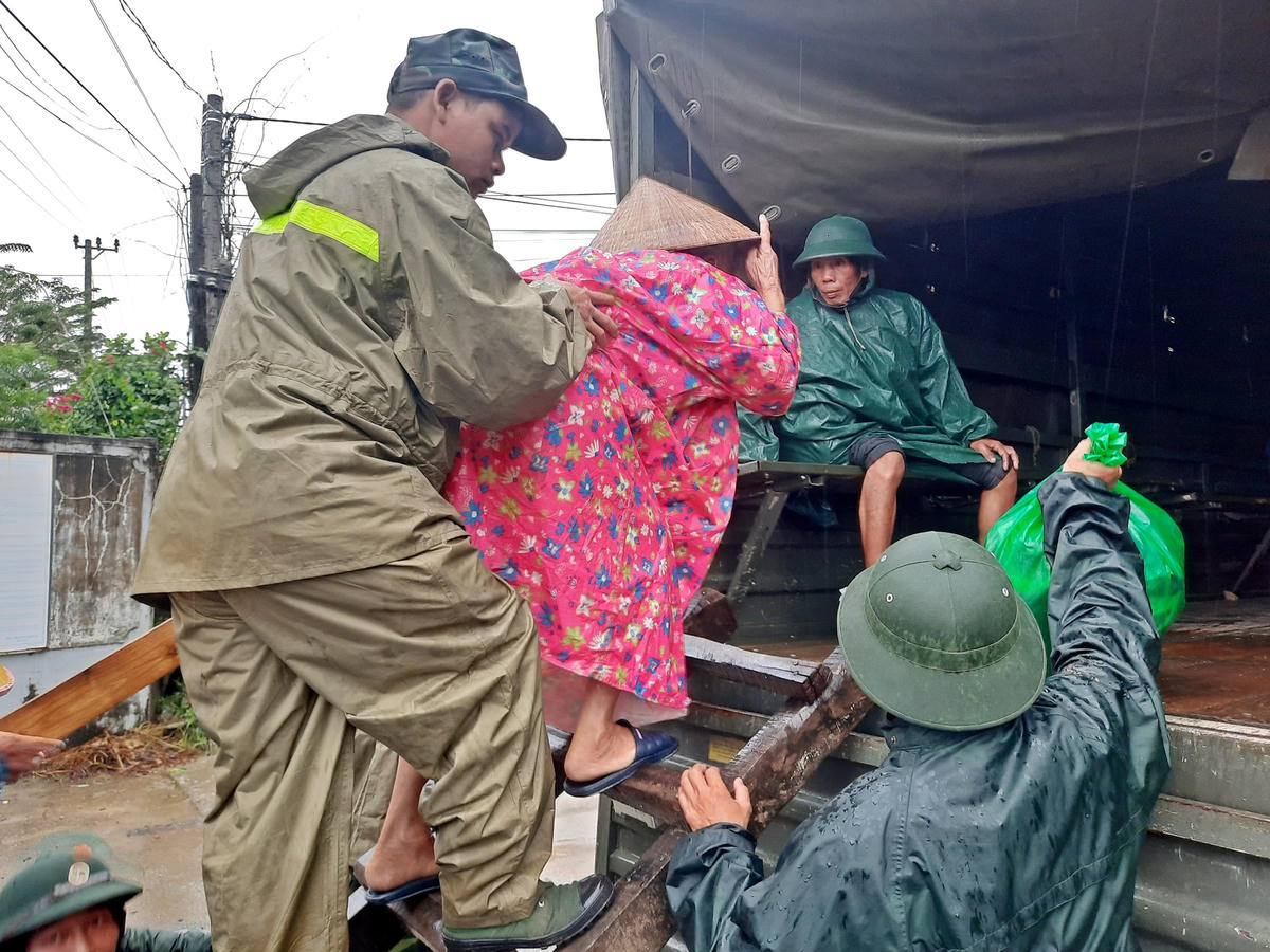 Lực lượng chức năng đưa người dân lên xe đến nơi an toàn.