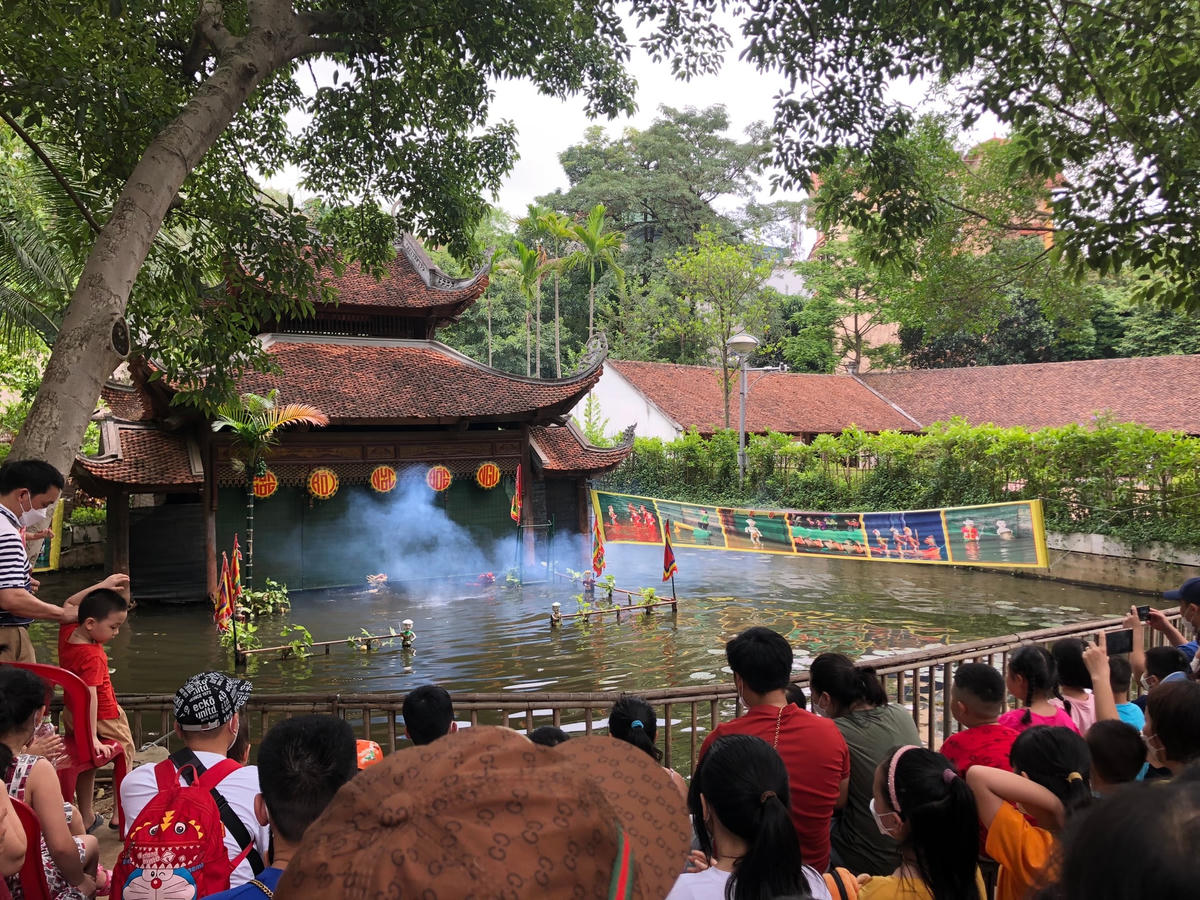 Khách tham quan thưởng thức nghệ thuật trình diễn múa rối nước.