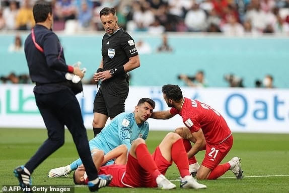 Cả hai cầu thủ của Iran nằm sân đau đớn sau pha va chạm (Ảnh: Getty).