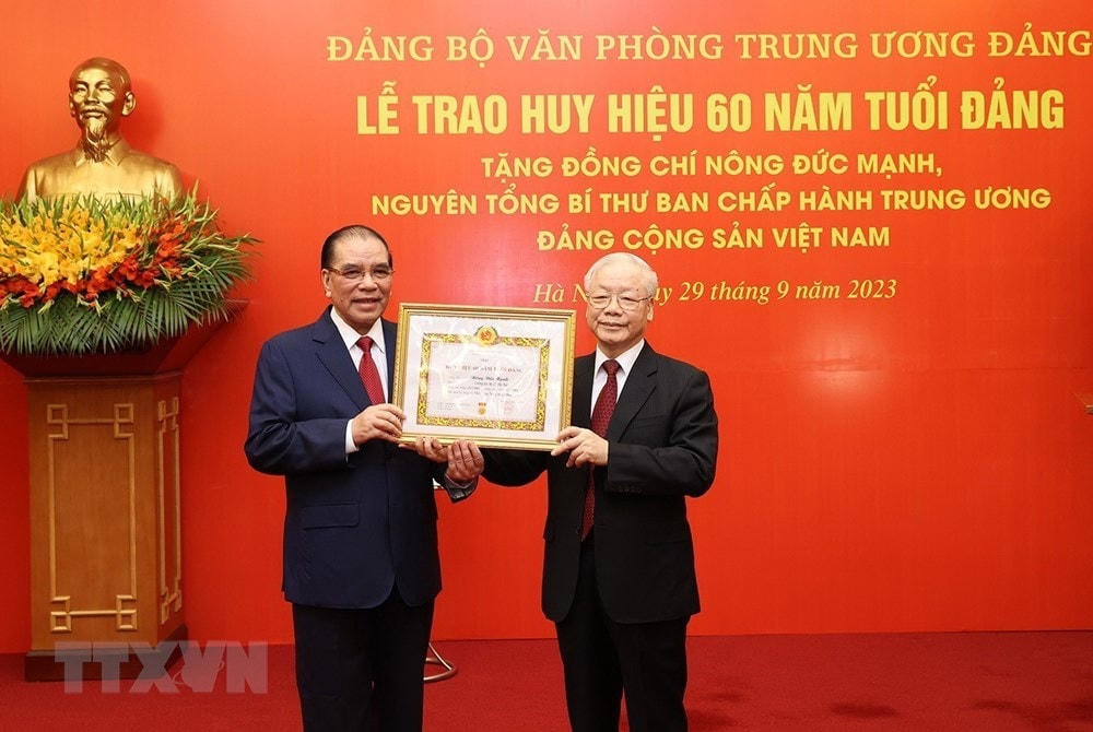 Tổng Bí thư Nguyễn Phú Trọng trao Huy hiệu 60 năm tuổi Đảng cho nguyên Tổng Bí thư Nông Đức Mạnh. (Ảnh: Trí Dũng/TTXVN).