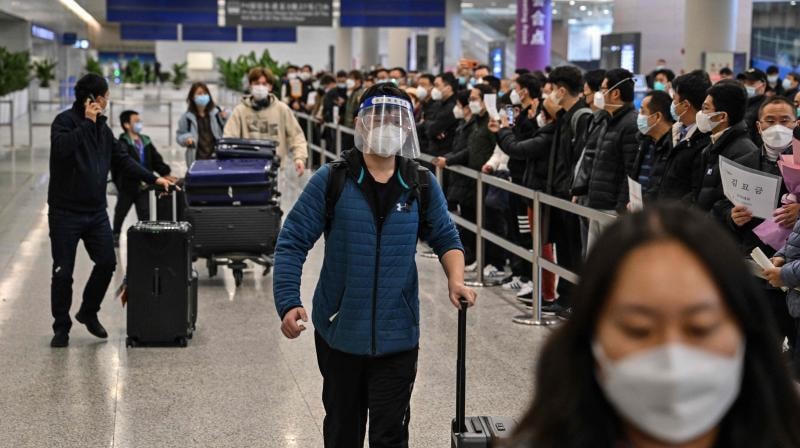 Những vị khách đầu tiên từ các chuyến bay quốc tế nhập cảnh Trung Quốc ngày 8/1. Ảnh: AFP.