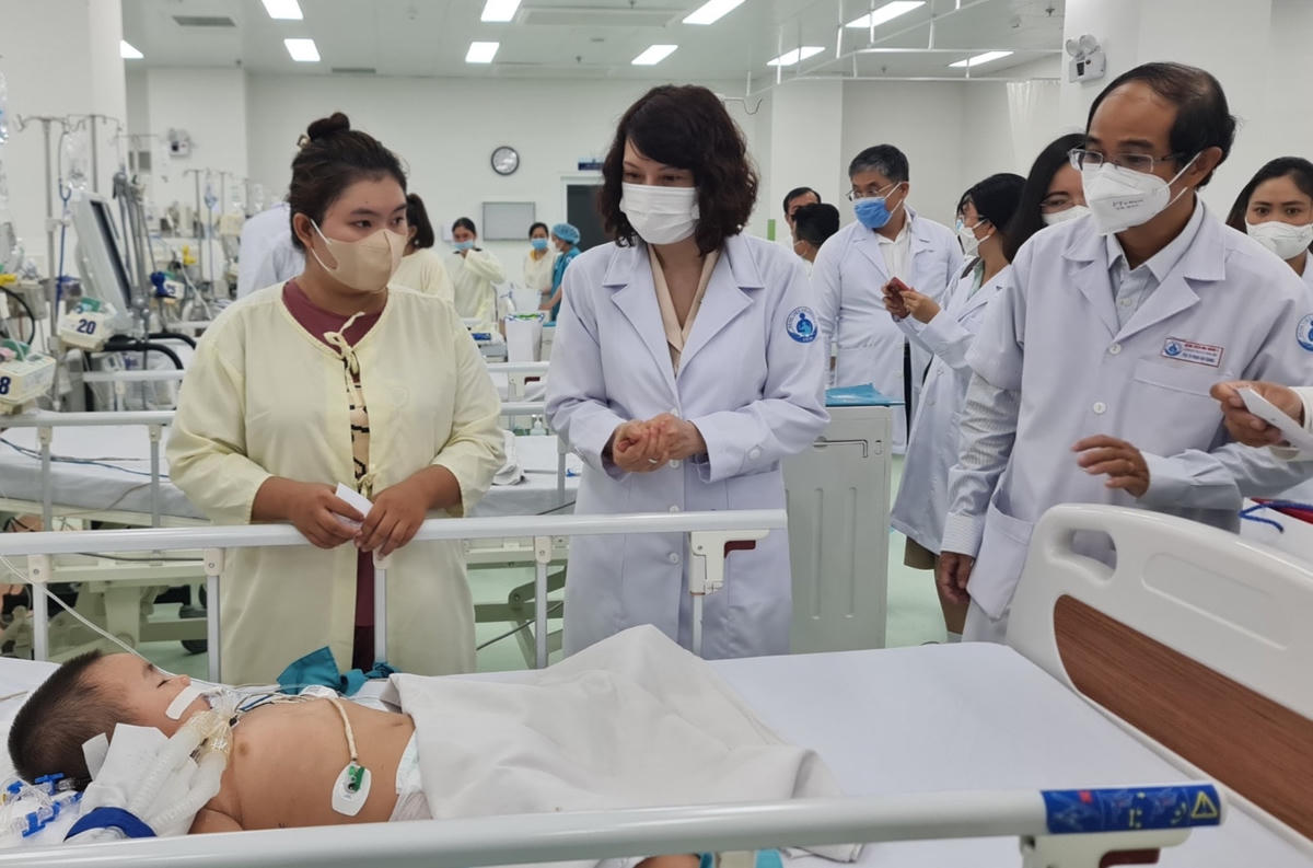 Thứ trưởng Bộ Y tế Nguyễn Thị Liên Hương (giữa) thăm bệnh nhi bị tay chân miệng điều trị tại Bệnh viện Nhi đồng 1 (TPHCM).