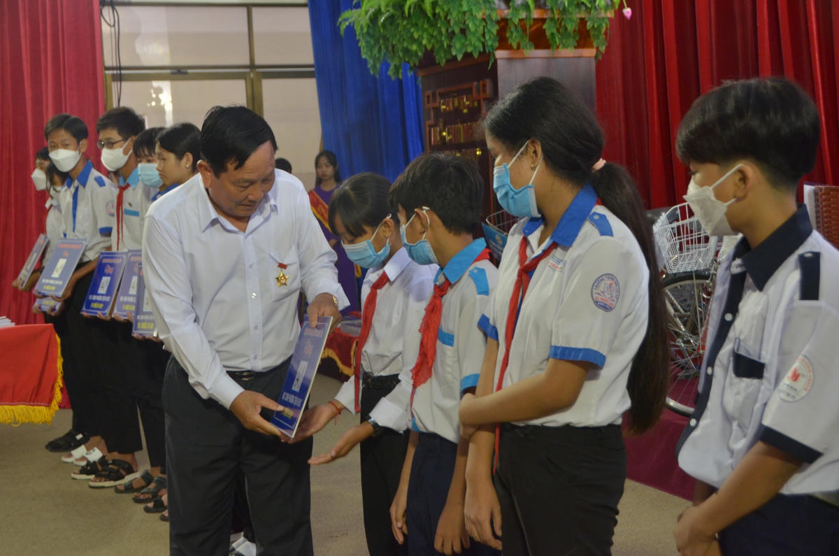 Các nhà tài trợ, nhà hảo tâm trao học bổng cho các học sinh vượt khó, hiếu học.