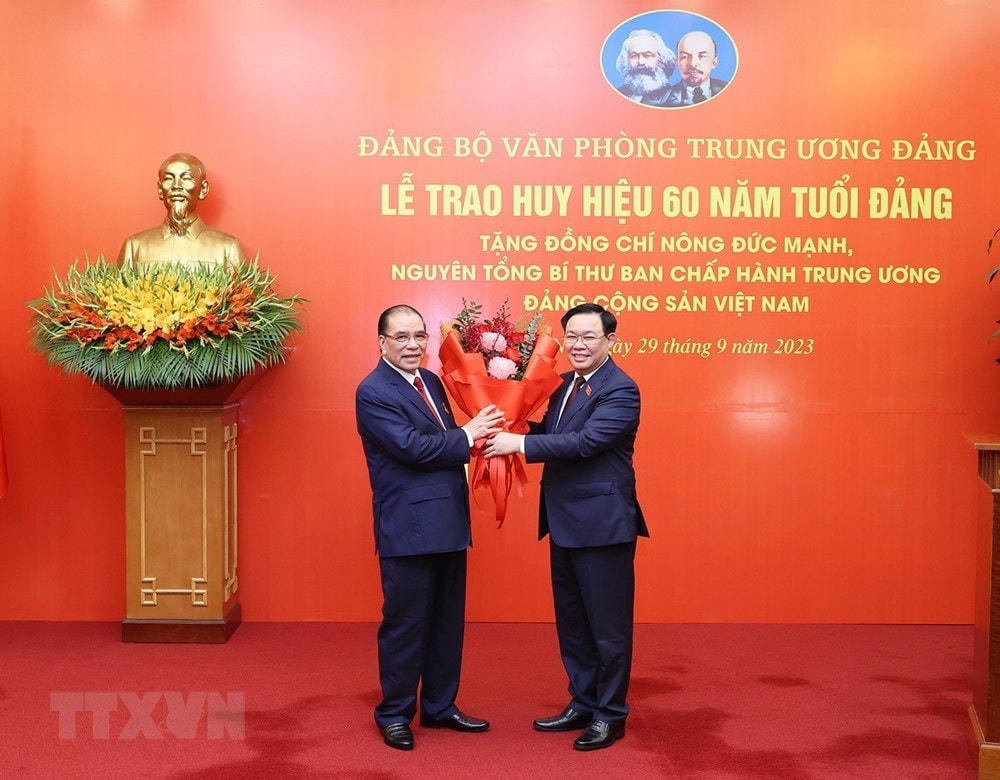 Đồng chí Vương Đình Huệ, Ủy viên Bộ Chính trị, Chủ tịch Quốc hội, chúc mừng nguyên Tổng Bí thư Nông Đức Mạnh. (Ảnh: Trí Dũng/TTXVN).