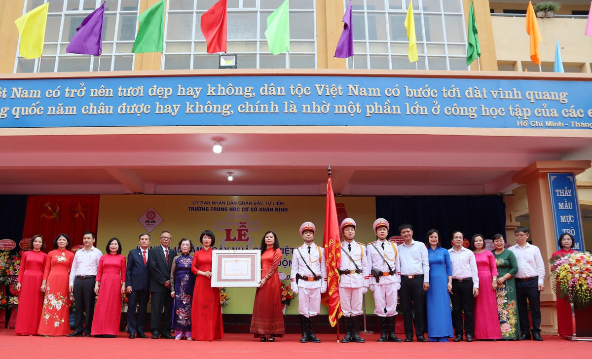 Trao Bằng chứng nhận Huân chương Lao động hạng Nhì cho Ban giám hiệu nhà trường.