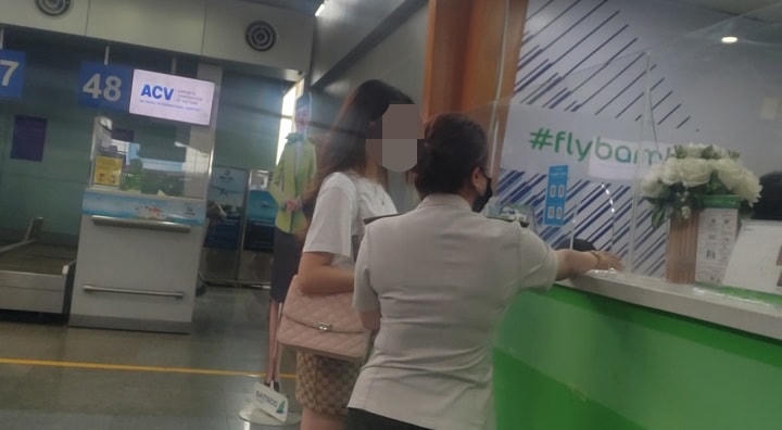 Người mặc trang phục an ninh sân bay Cảng hàng không quốc tế Đà Nẵng hỗ trợ 1 khách hàng không có giấy tờ tuỳ thân lên máy bay tại quầy vé của hãng Bamboo Airways.