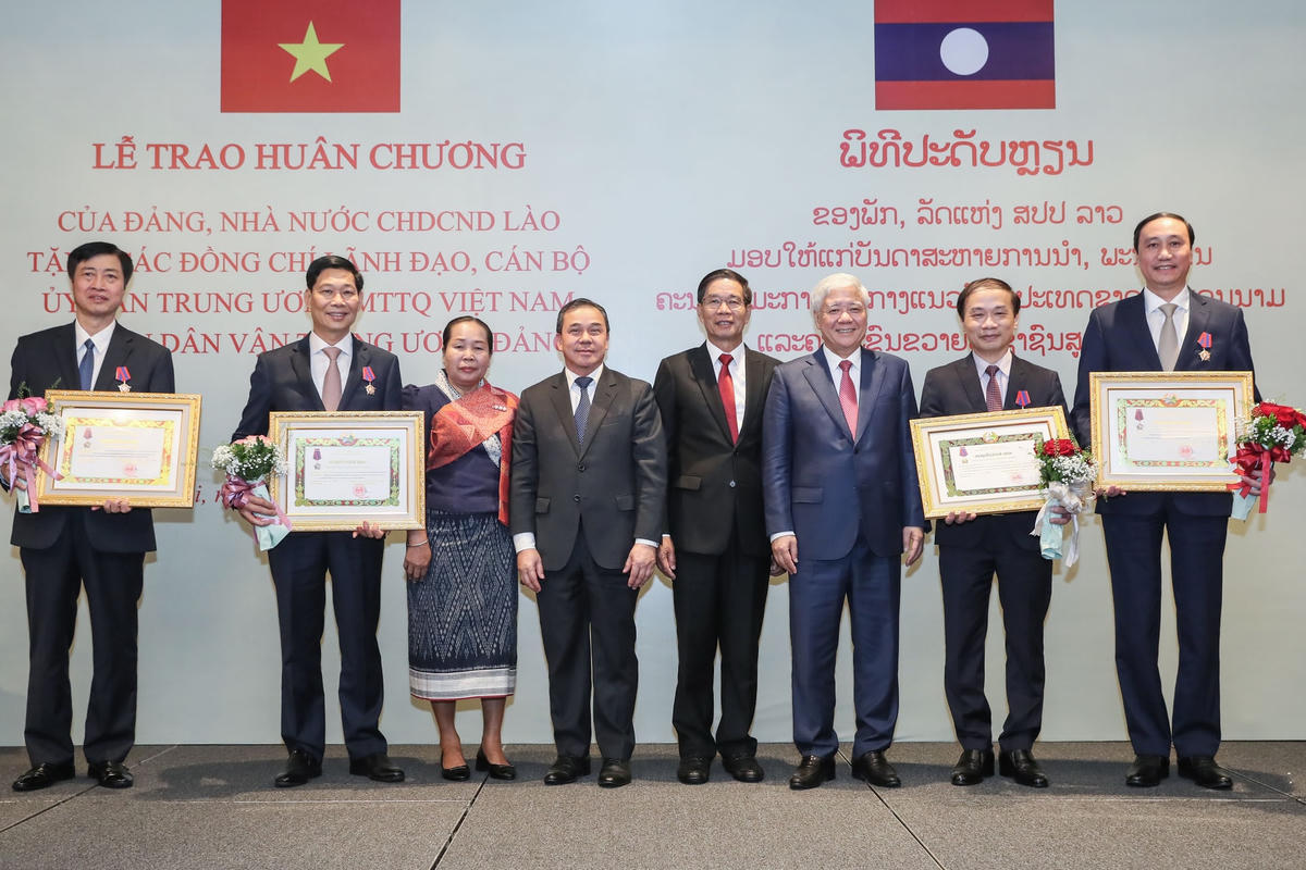Chủ tịch Uỷ ban Trung ương Mặt trận Lào xây dựng đất nước Sinlavong Khoutphaythoune và Chủ tịch UBTƯ MTTQ Việt Nam Đỗ Văn Chiến chụp ảnh lưu niệm với các đồng chí lãnh đạo, cán bộ UBTƯ MTTQ Việt Nam và Ban Dân vận Trung ương được trao thưởng Huân chương Ít-xa-la. Ảnh: Quang Vinh.