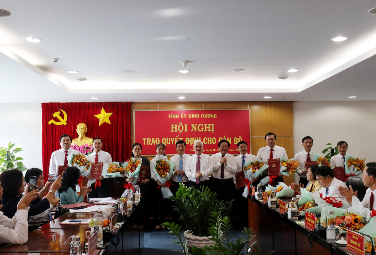 Bí thư Tỉnh ủy Nguyễn Văn Lợi (giữa), Phó Bí thư Thường trực Tỉnh ủy Nguyễn Hoàng Thao (thứ 5 từ phải qua), Chủ tịch UBND tỉnh Võ Văn Minh (thứ 5 từ trái qua) trao quyết định và tặng hoa cho các nhân sự được điều động, bổ nhiệm, bổ nhiệm lại