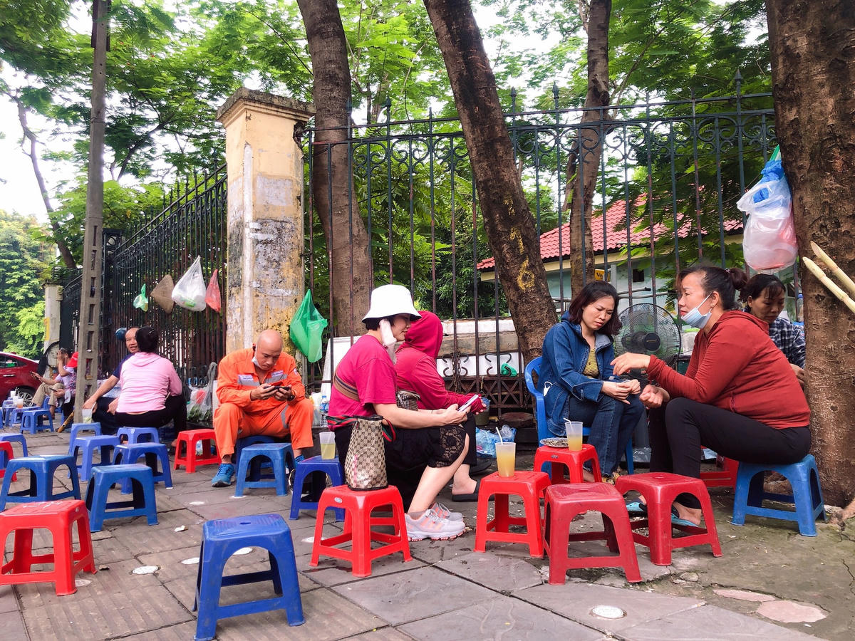 Phụ huynh "tám chuyện" ở quán trà đá đối diện điểm thi Trường THCS Nghĩa Tân (quận Cầu Giấy).