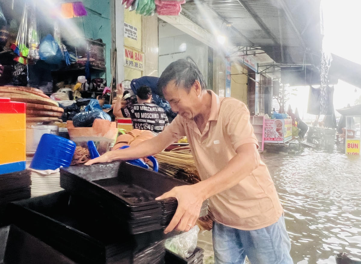 Người dân ở chợ Tam Kỳ di chuyển đồ đạc lên vị trí cao.