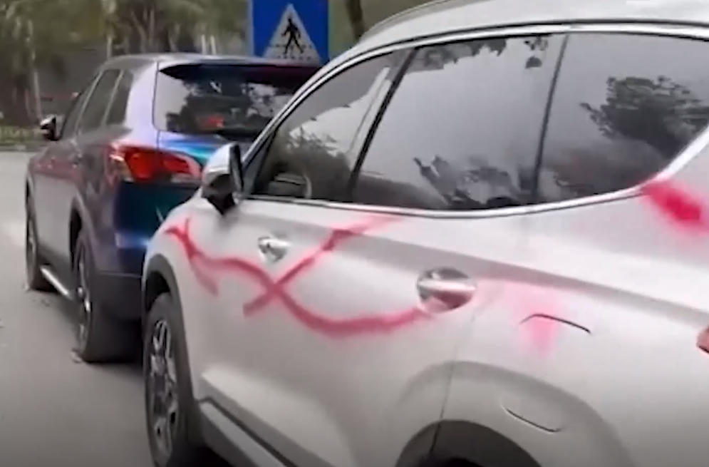 Ô tô đậu trên vỉa hè gần khu chung cư bị xịt sơn hồng. Ảnh cắt từ clip
