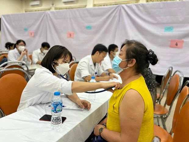 Nhân viên y tế khám sàng lọc bệnh cho người dân.  