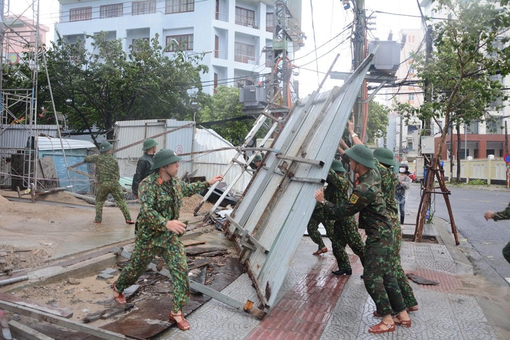 Lực lượng bộ đội hỗ trợ dọn dẹp vệ sinh đường phố sau khi bão đổ bộ. (Ảnh: Văn Dũng/TTXVN).