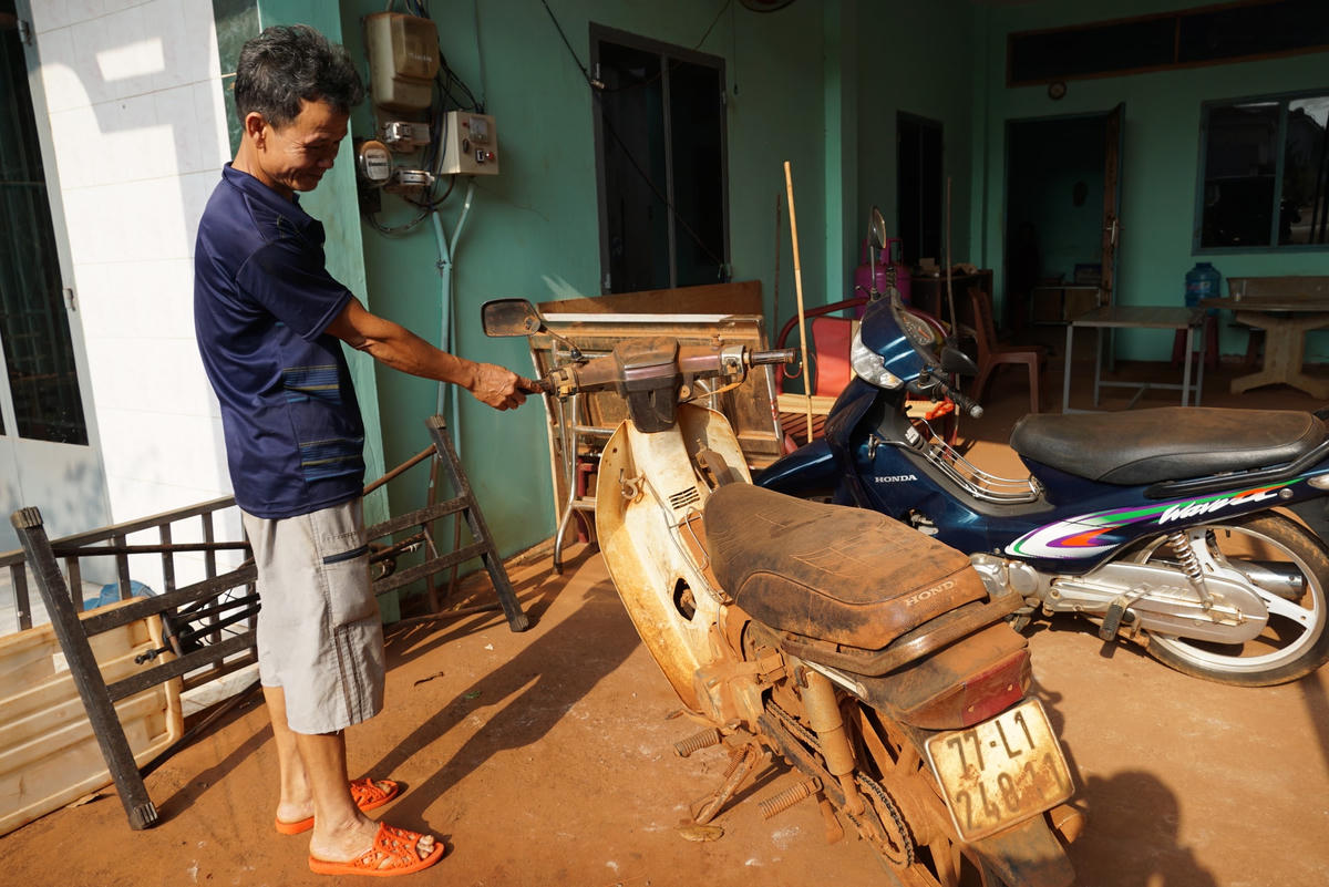 Chiếc xe máy để ngoài sân của ông Trần Hữu Lộc ở ấp 1, xã Bình Sơn cũng bám đầy bụi đỏ.