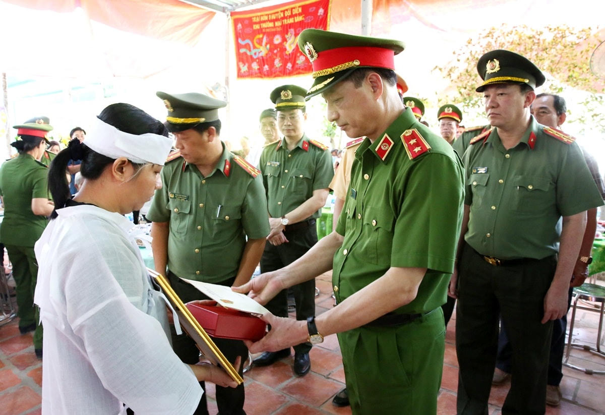 Trung tướng Nguyễn Duy Ngọc trao quyết định thăng cấp bậc hàm cho gia đình đồng chí Nguyễn Xuân Hào. Ảnh: Công an tỉnh Long An.