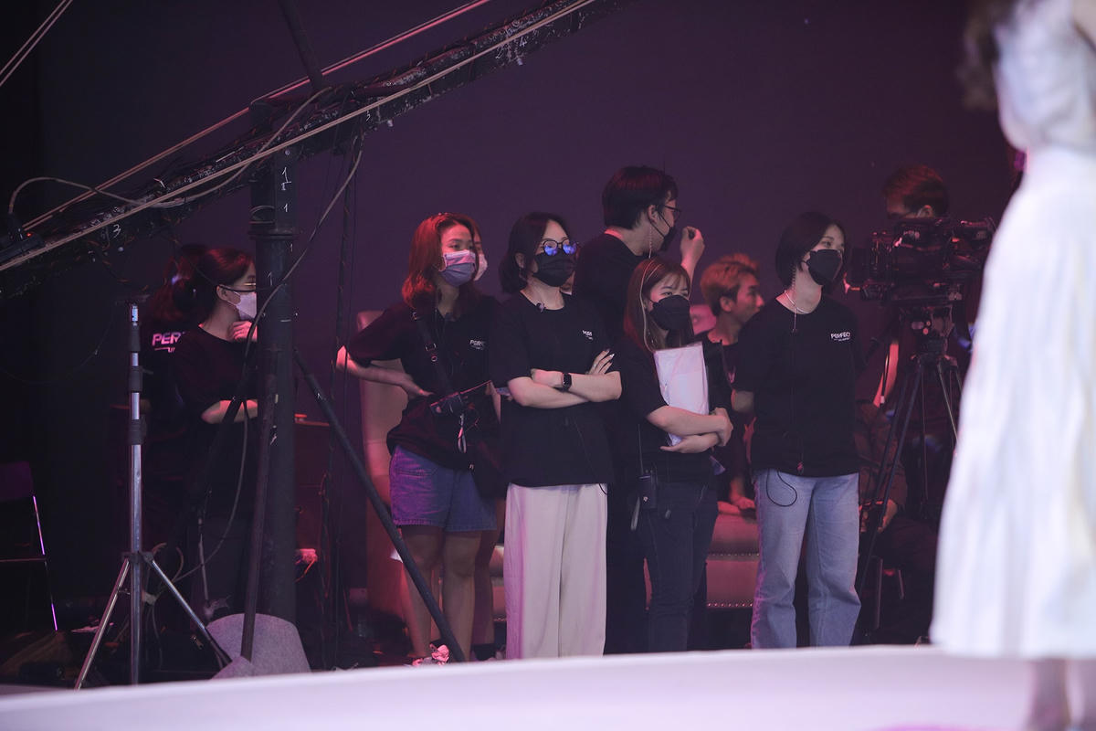 Hoàng Anh (người đứng giữa, đeo kính) vẫn tập trung làm việc khi chương trình bắt đầu. Ảnh: Perfect Universe.