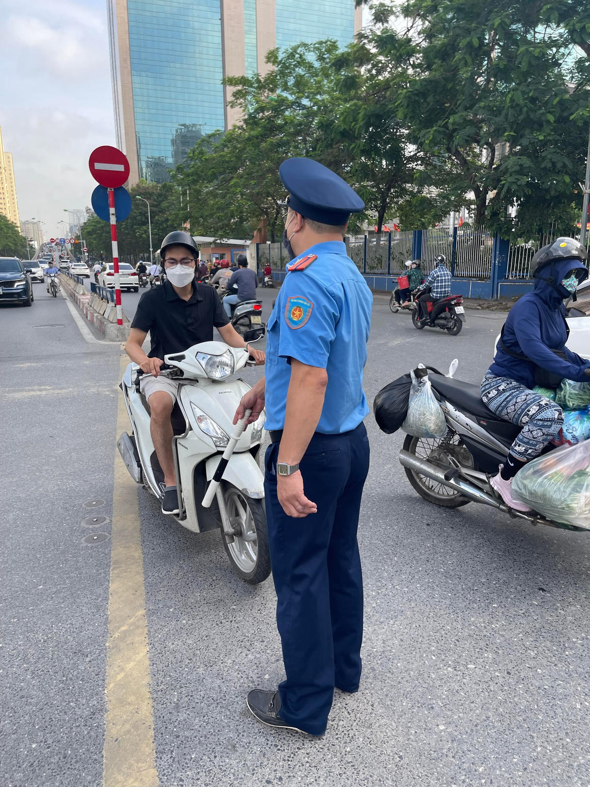 Thanh tra giao thông đang giải thích và hướng dẫn người tham gia giao thông tại nút giao Hoàng Minh Giám - Hoàng Ngân.
