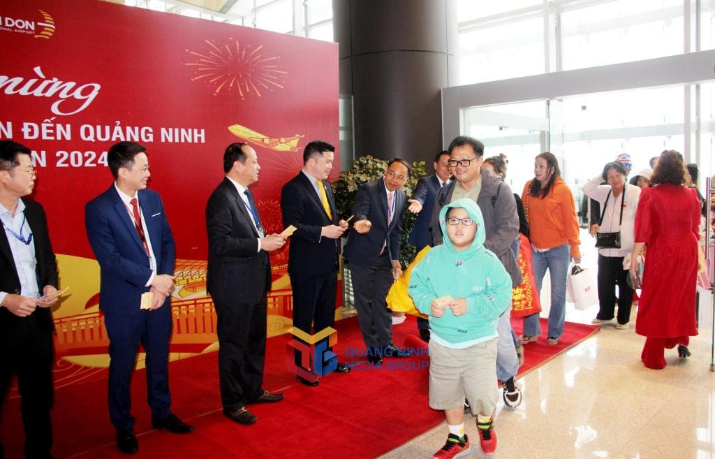 Đại diện lãnh đạo huyện Vân Đồn và Cảng hàng không quốc tế Vân Đồn chào đón những vị khách trên chuyến bay “xông đất” Quảng Ninh năm Giáp Thìn 2024. Ảnh: QMG.