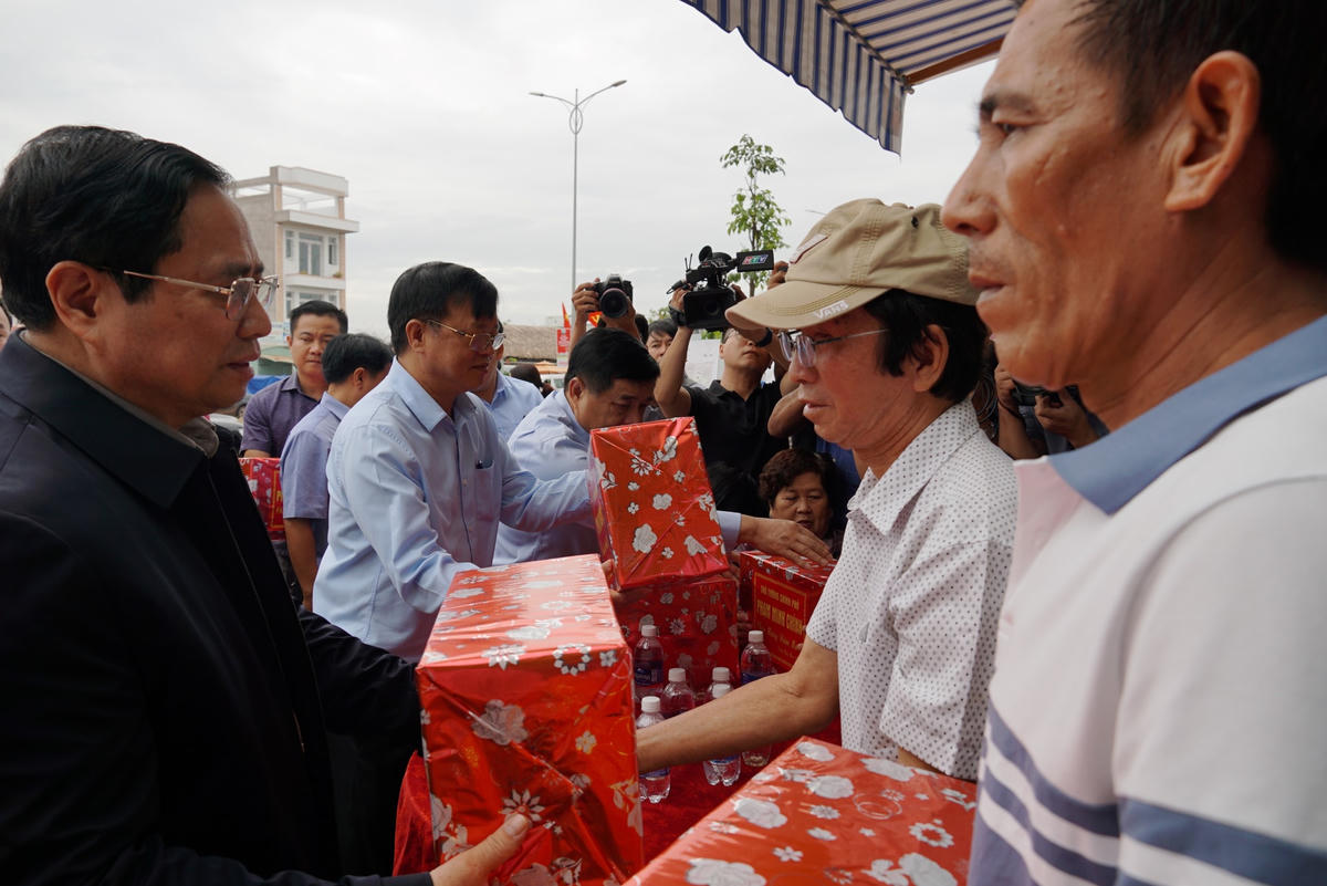 Thủ tướng Phạm Minh Chính đã tặng quà, chúc mừng người dân khu tái định cư; gửi những lời chúc tốt đẹp đến toàn thể nhân dân. Ảnh: Mạnh Thìn.
