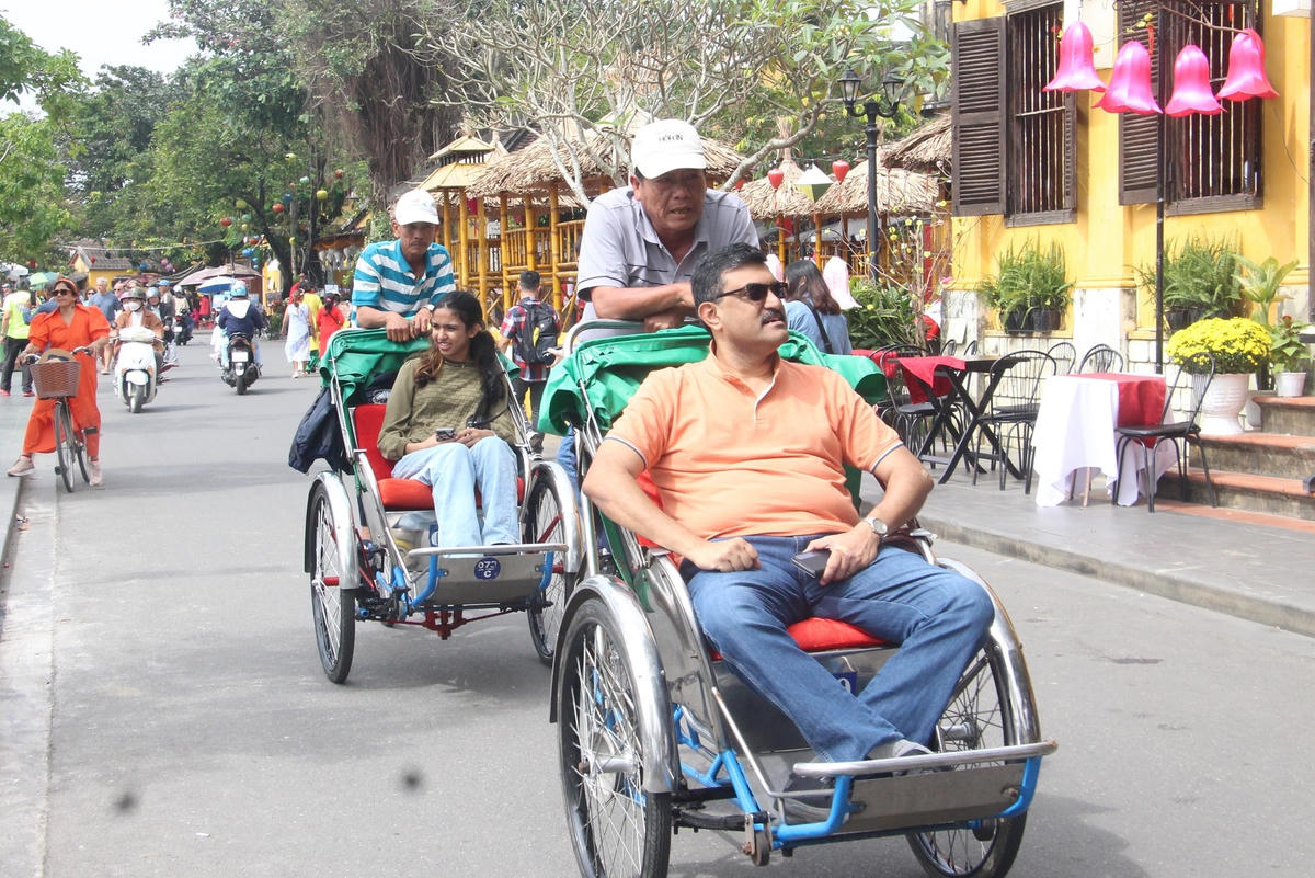 Du khách nước ngoài ngồi xích lô tham quan phố cổ Hội An.