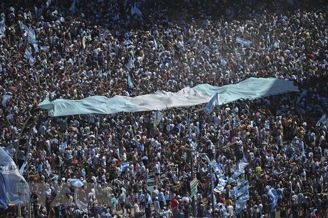 Cổ động viên Argentina đổ xuống đường phố thủ đô Buenos Aires, hạnh phúc với danh hiệu vô địch World Cup 2022 của các tuyển thủ quốc gia sau 36 năm đằng đẵng chờ đợi. (Ảnh: AFP/TTXVN)