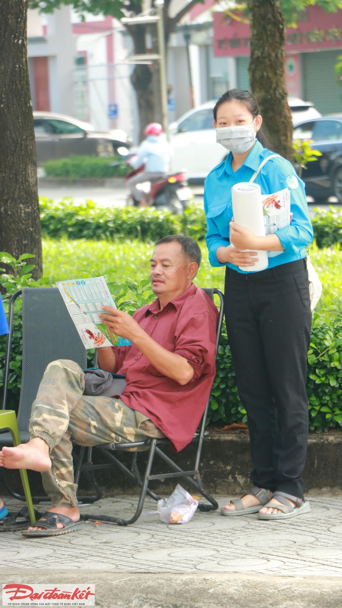 Một đoàn viên thanh niên phát tờ rơi, banner tuyên truyền về Luật giao thông đường bộ cho người dân tại khu dân cư TP Thủ Đức. (Ảnh: Lương Hợp).