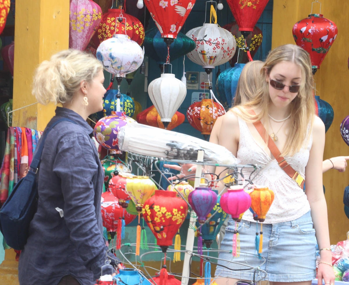 Du khách nước ngoài tham quan phố cổ Hội An và lực chọn mua lồng đèn.