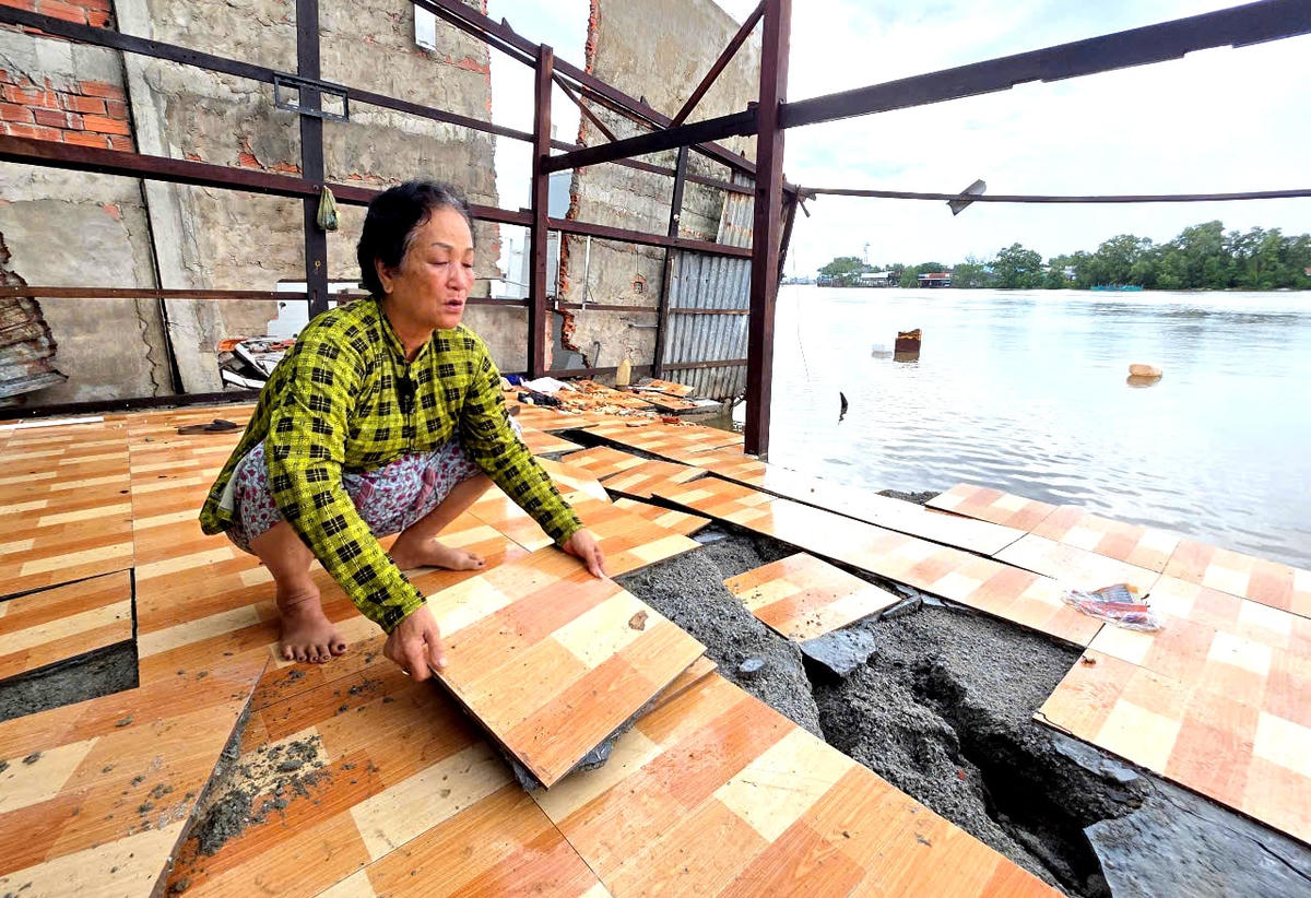 ẢNH 2 Bà Hoa gỡ những miếng gạch của căn nhà còn sót lại sau vụ sạt nghiêm trọng. Ảnh Nguyên Du.