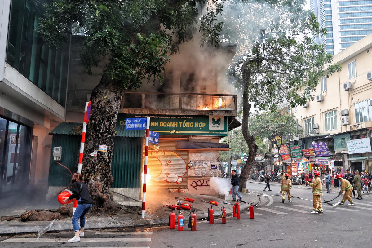 Người dân cùng các lực lượng chức năng tiến hành dập tắt đám cháy.