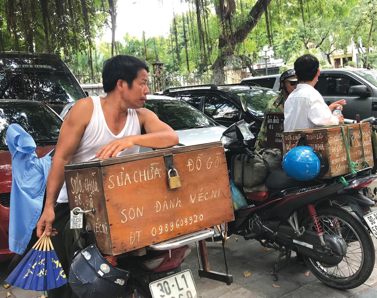 Những người sửa chữa đồ gỗ ở góc phố Nguyễn Đình Chiểu (quận Hai Bà Trưng, Hà Nội) chờ đợi khách.  