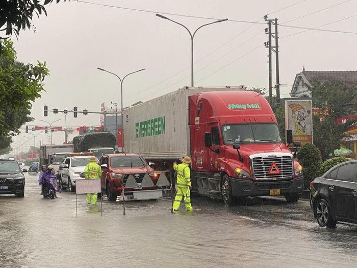 Đường QL1 (đoạn thị trấn Nghèn, huyện Can Lộc) ngập trong nước khiến phương tiện di chuyển khó khăn.