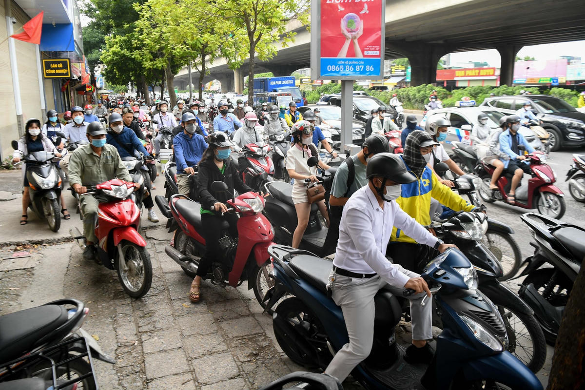 Do ùn tắc kéo dài các phương tiện thi nhau nối đuôi di chuyển trên vỉa hè.