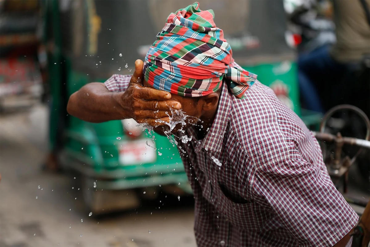 Người dân dùng nước để giải tỏa cơn nóng. Ảnh: Reuters.