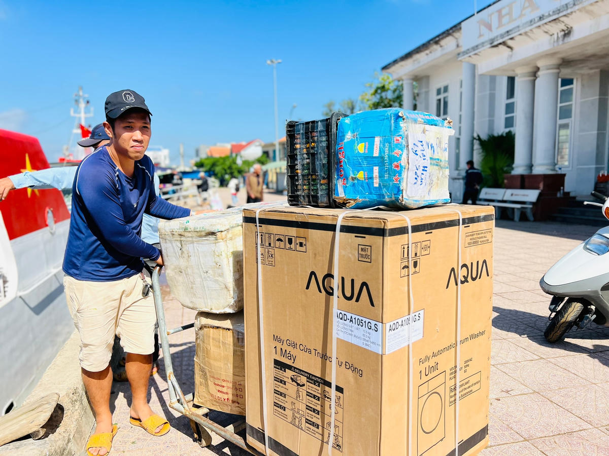 Người dân vận chuyển hàng hóa xuống tàu để ra đảo Lý Sơn.