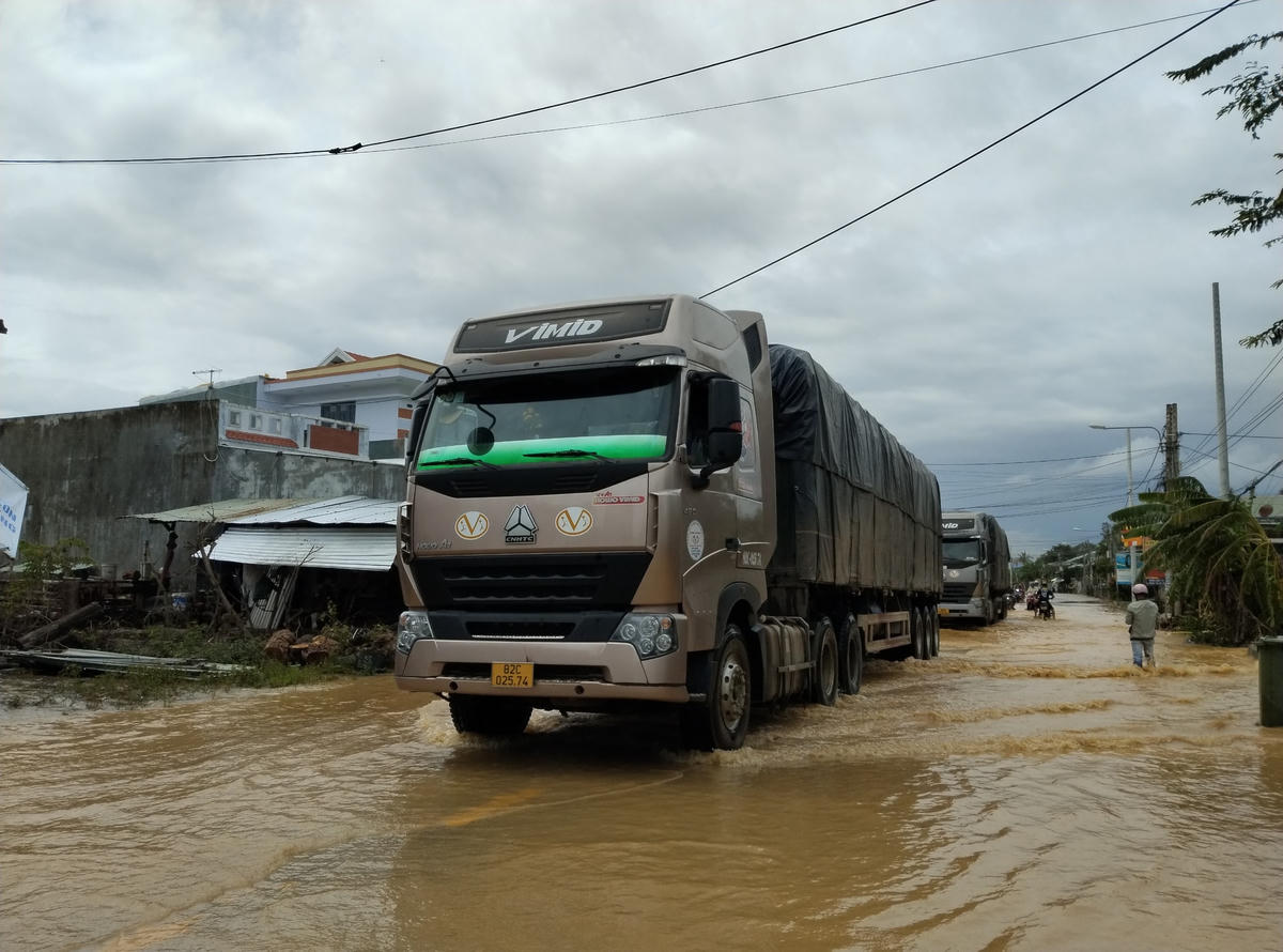 Phương tiện lưu thông qua đoạn đường ngập nước ở thị trấn Ái Nghĩa khó khăn.