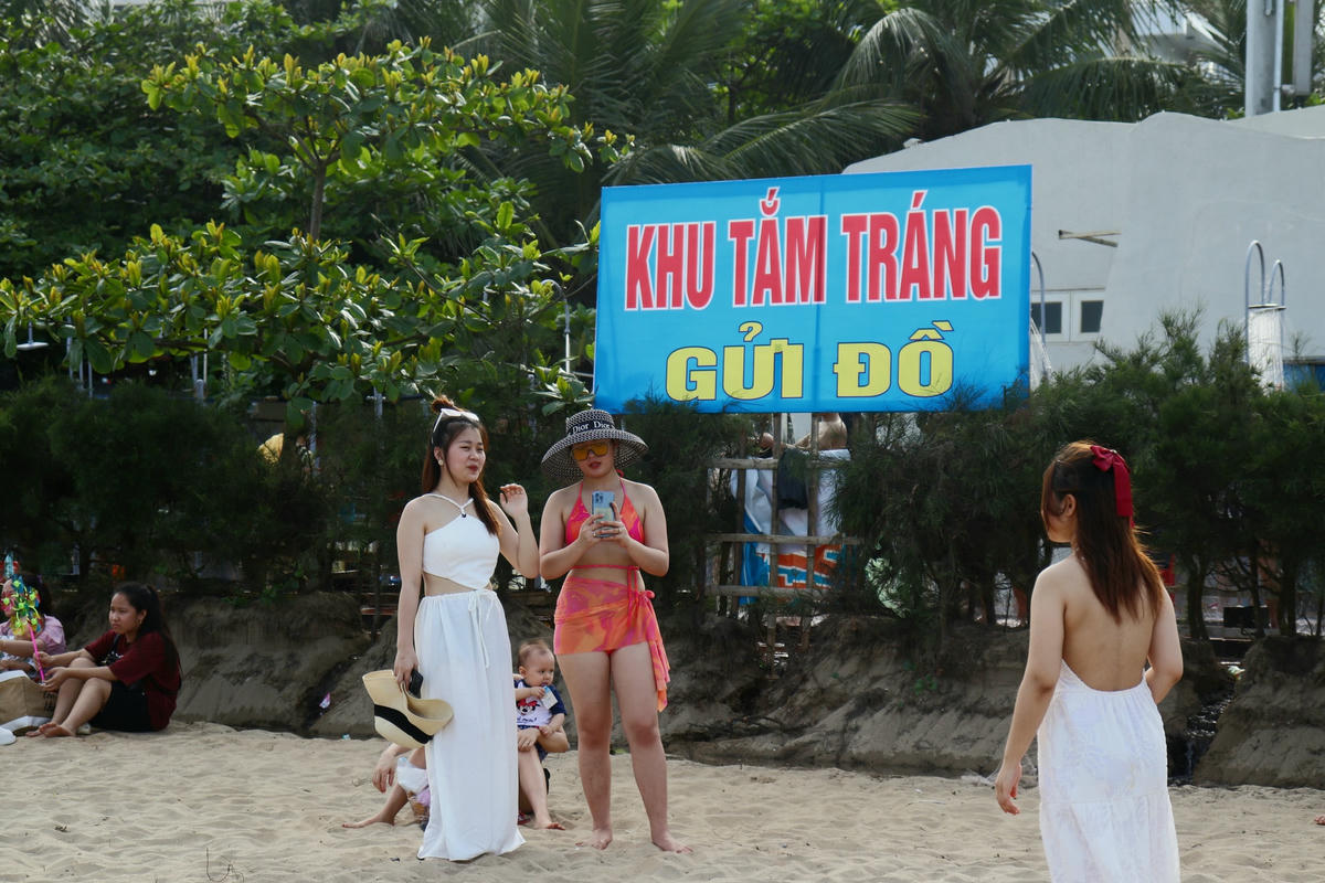 Trước khung cảnh đông nghịt người tắm biển, một số bạn trẻ đã lựa chọn ở trên bờ để check-in.