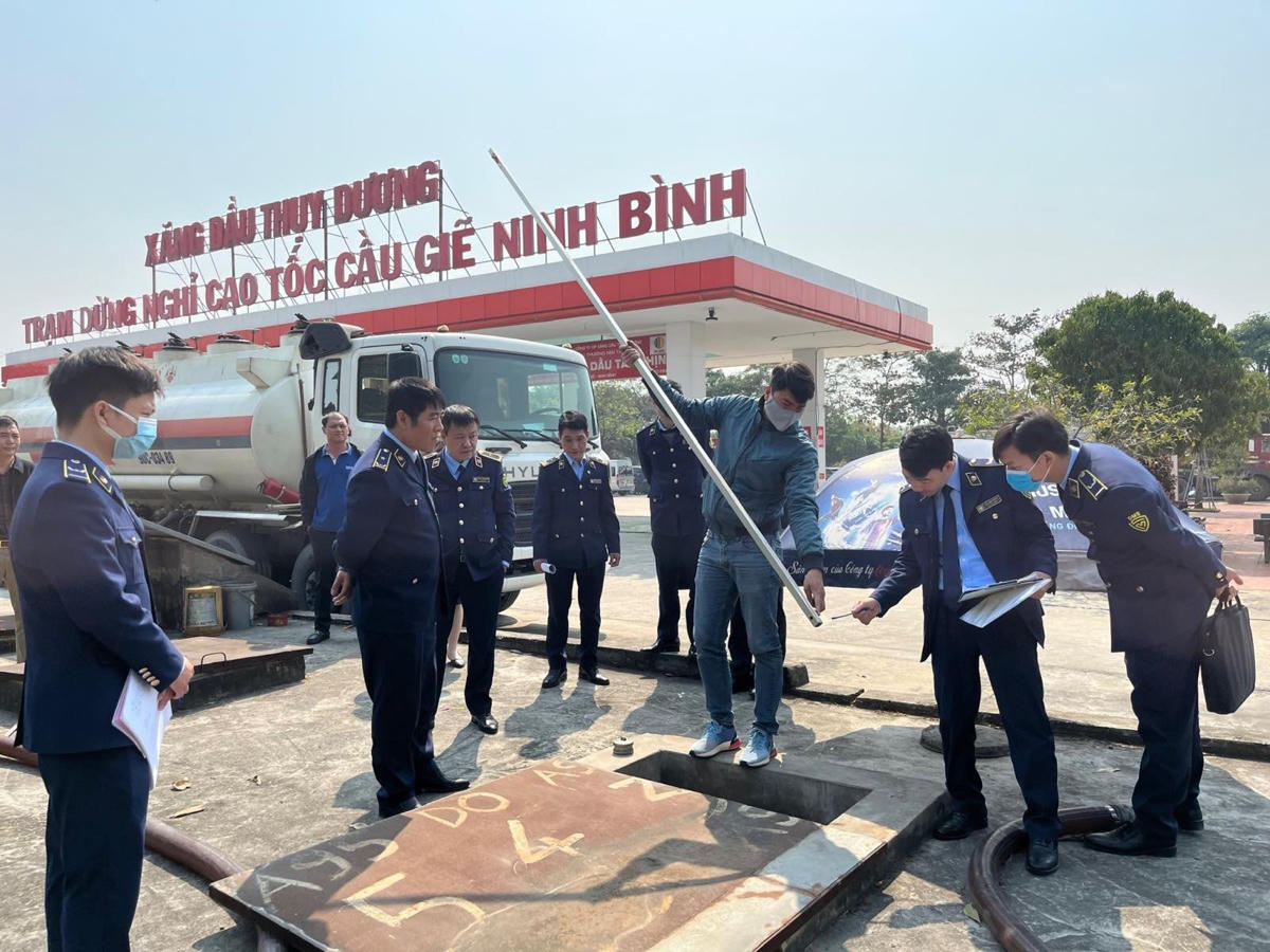 Lực lượng QLTT tiến hành đo lượng xăng dầu tại bể chứa tại cửa hàng xăng dầu Thuỵ Dương. (Ảnh: Phong Vân).