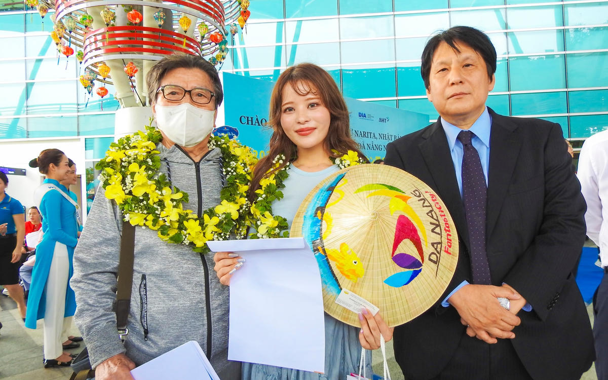 Tổng lãnh sự Nhật Bản tại Đà Nẵng Yakabe Yoshinori (phải) và 2 du khách đầu tiên từ Narita đặt chân xuống ga quốc tế sân bay Đà Nẵng. Ảnh: Thanh Tùng.