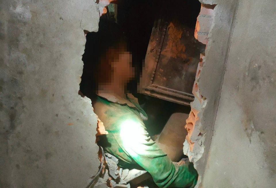 Lực lượng chức năng cùng người dân phải đục tường để đưa ông Minh ra ngoài. Ảnh: CACC.