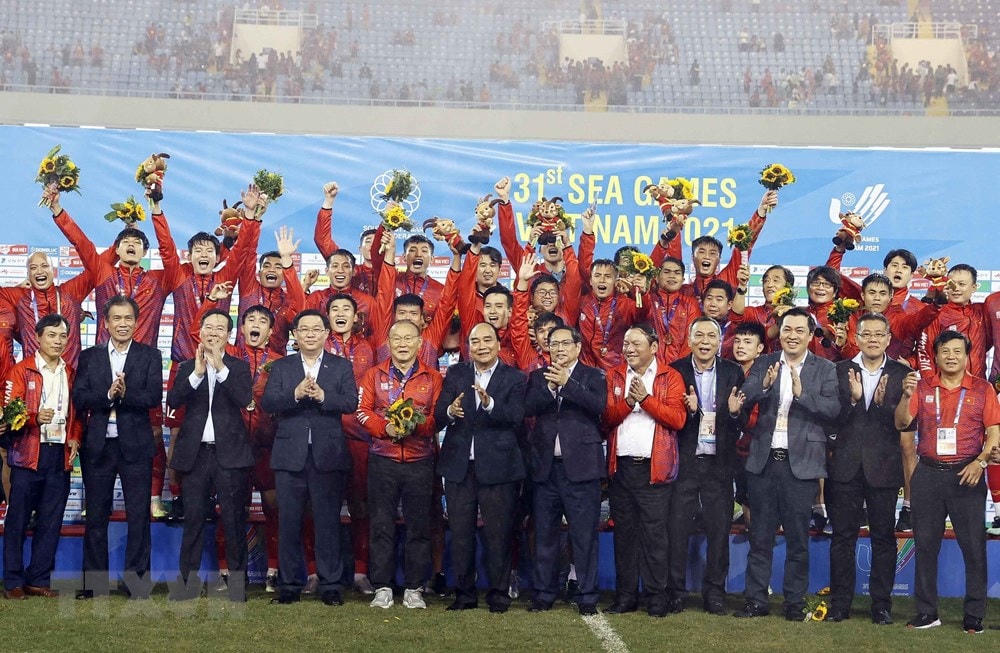 Chủ tịch nước Nguyễn Xuân Phúc, Thủ tướng Phạm Minh Chính, Chủ tịch Quốc hội Vương Đình Huệ, Thường trực Ban Bí thư Võ Văn Thưởng và các đại biểu chụp ảnh chung với Đội tuyển bóng đá U23 Việt Nam vừa giành Huy chương Vàng môn bóng đá nam SEA Games 31. Ảnh: TTXVN.