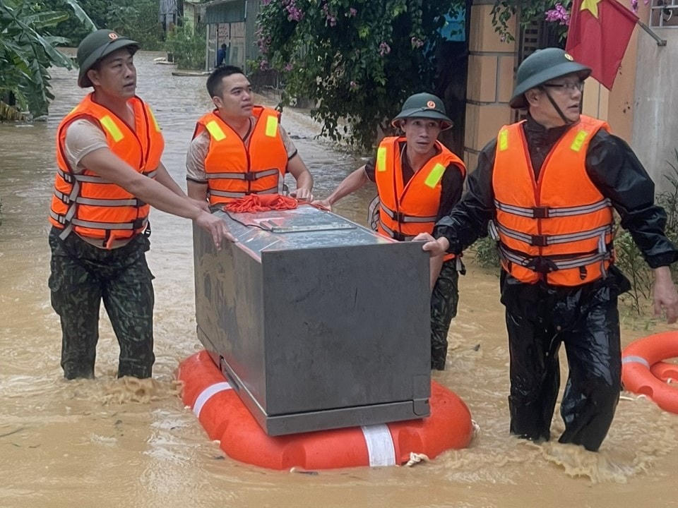 Lực lượng chức năng giúp người dân di chuyển đồ đạc lên cao.
